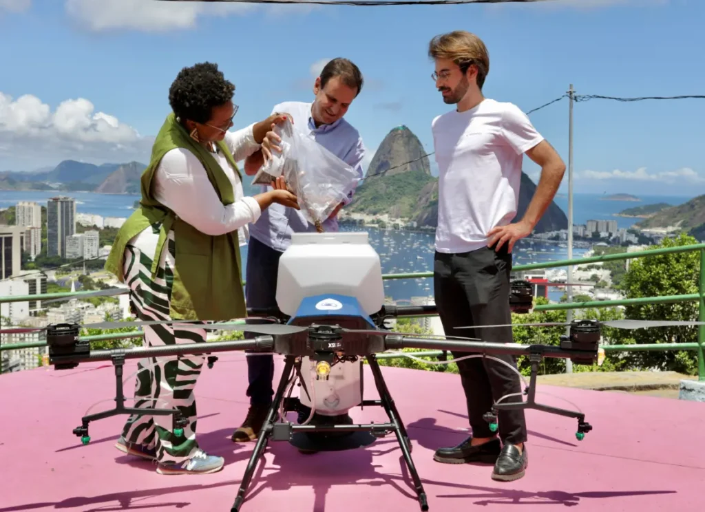 Tainá de Paula, Secretária de Meio Ambiente, e Eduardo Paes, Prefeito do Rio, abastecem o drone com sementes ao lado de Adrien Pages, CEO da Morfo. Foto:Beth Santos/Prefeitura do Rio