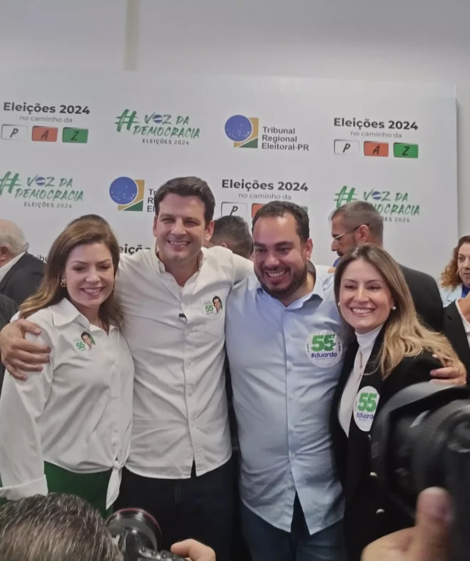 Eduardo abraça a esposa Paula e o vice, Paulo Martins. 