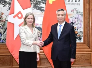 _Ao lado de Li Xi, alto funcionário do Partido Comunista da China, durante reunião em Pequim