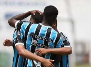 Jogadores do Grêmio comemorando um gol, com destaque para a marca da Gerdau na camiseta. Crédito: Renan Jardim/Grêmio FBPA